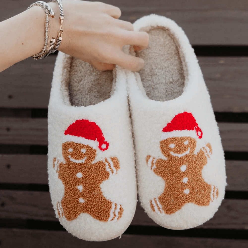 a woman holding up gingerbread slippers