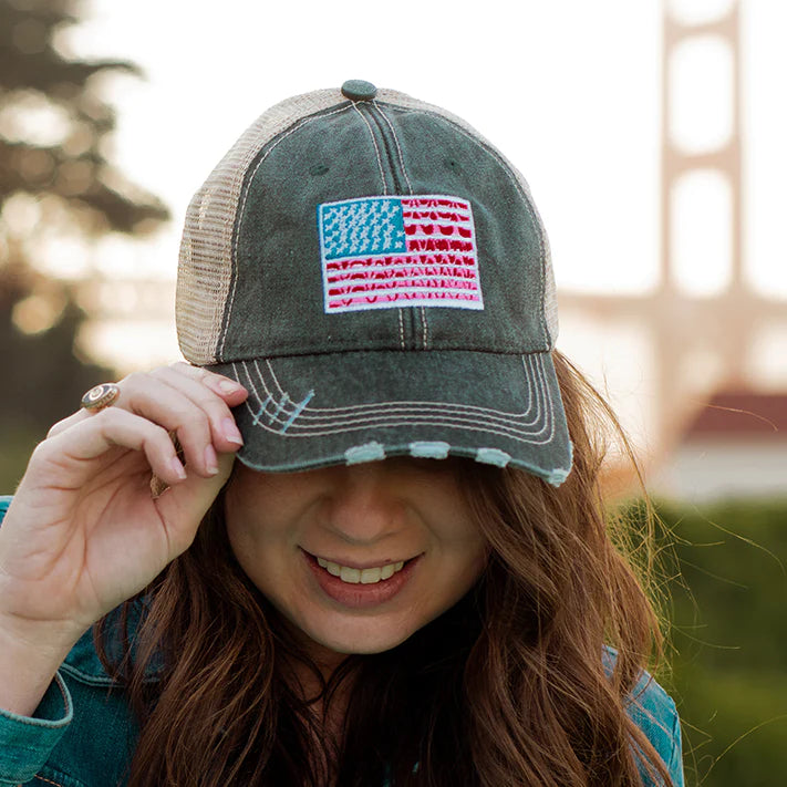 woman in a distressed American flag trucker hat