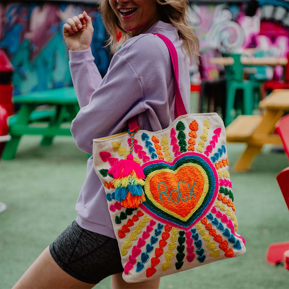 blonde woman with a multi-colored tote on her shoulder