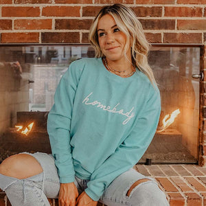 woman in aqua homebody sweatshirt and distressed jeans