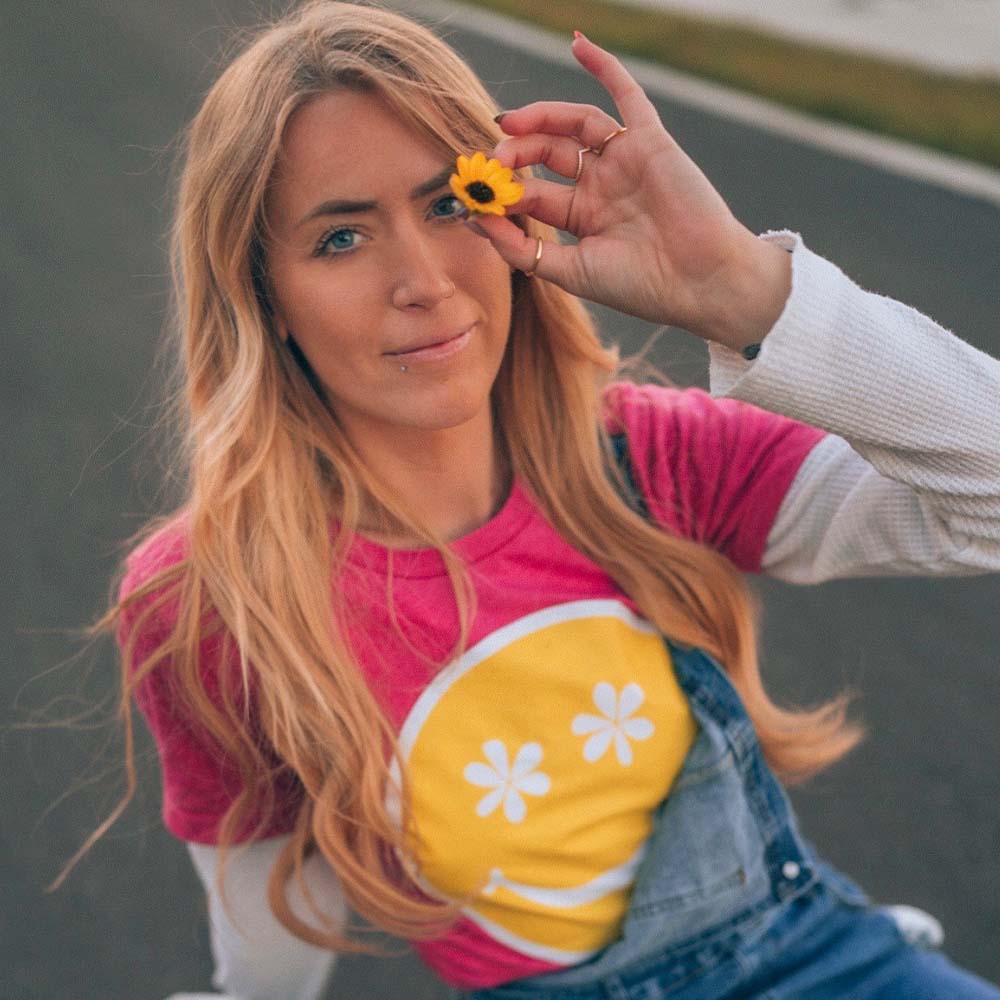 woman in a pink happy face graphic tee