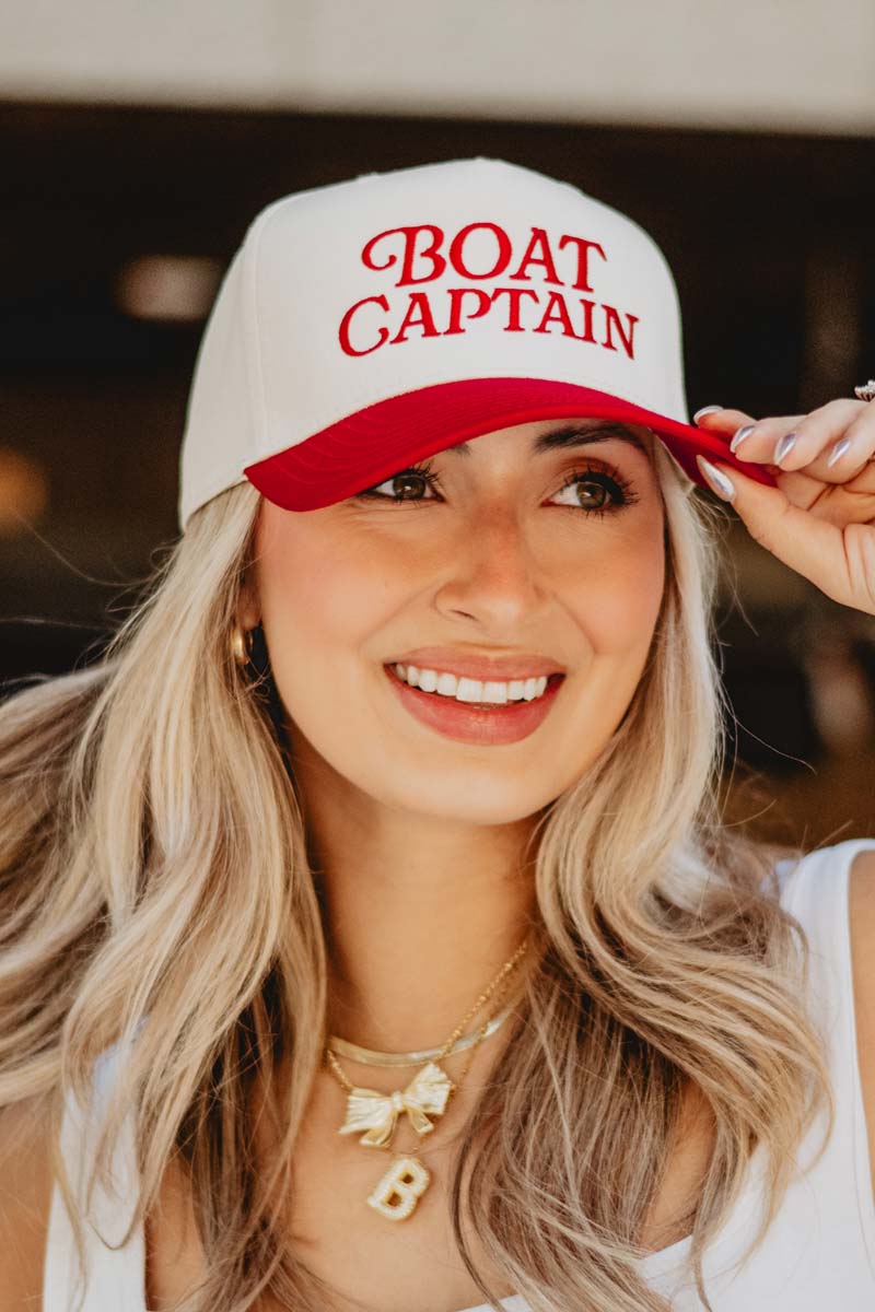 A woman wearing a red and white boat captain hat