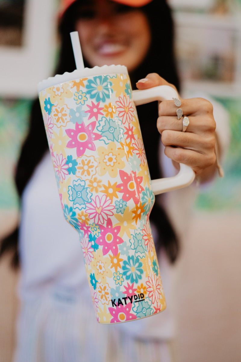 A woman holding a colorful multicolor tumbler with trendy floral design