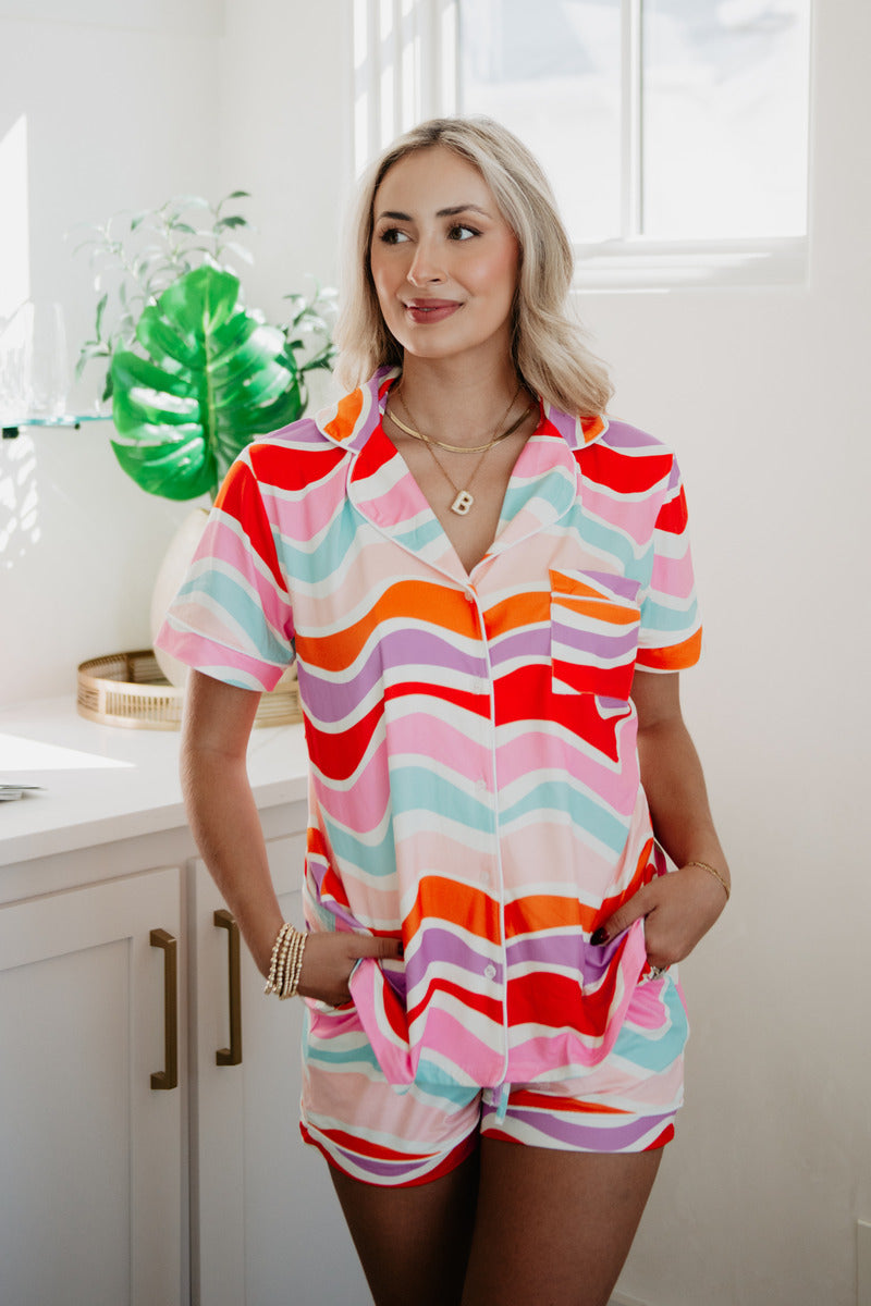 A woman standing in a bathroom wearing a colorful wave pajama set