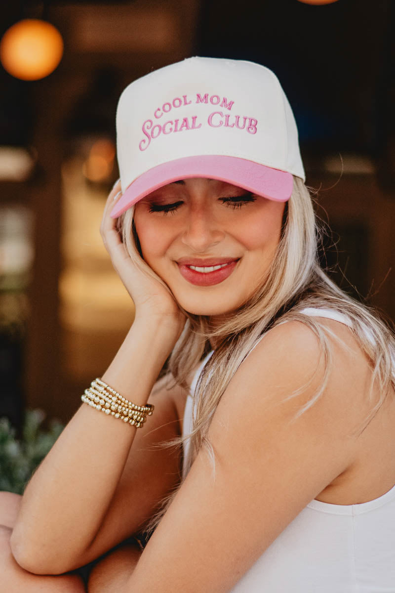 A woman wearing a pink and white hat Cool Mom Social Club