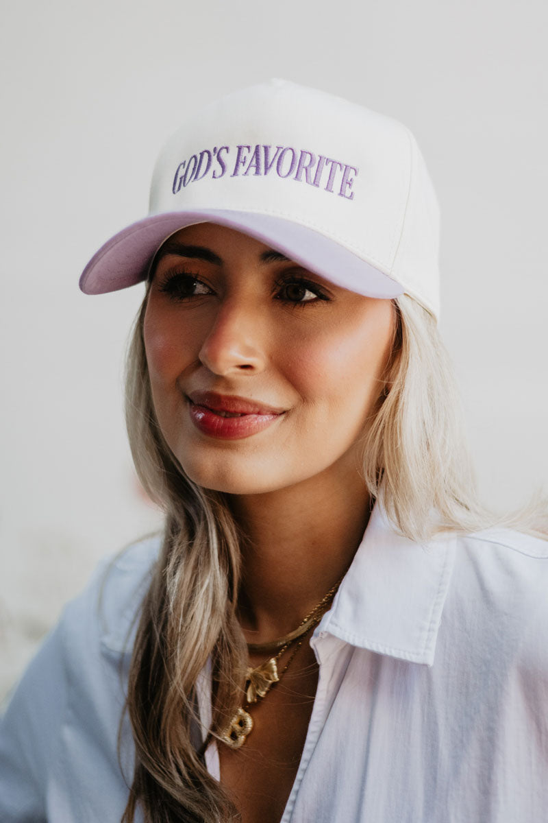 Woman wearing a white and lavender Gods Favorite Trucker Hat