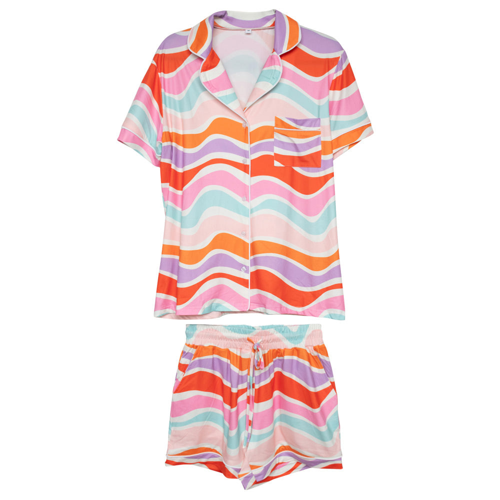 A woman standing in a bathroom wearing a colorful wave pajama set