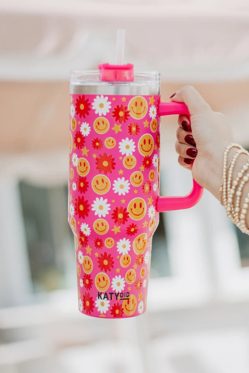 A red floral tumbler with straw