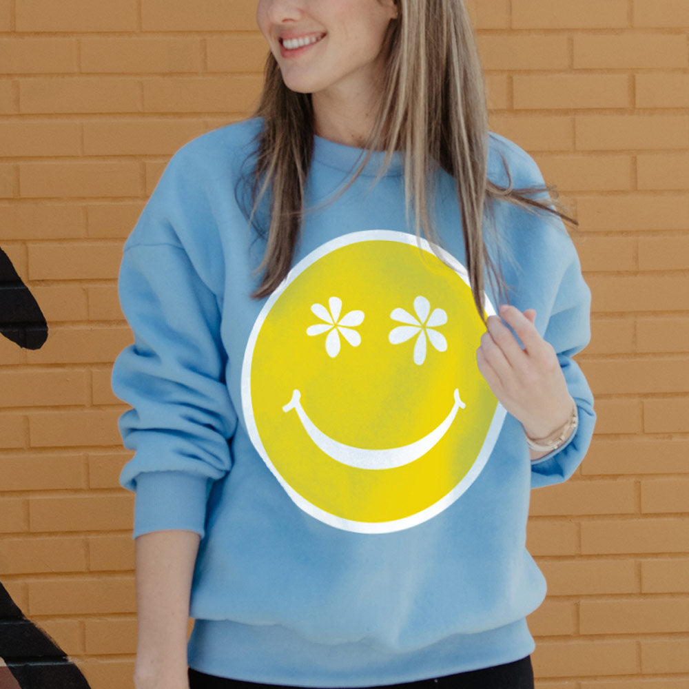 https://www.katydidwholesale.com/cdn/shop/products/graphics-sweatshirts-smiley-face-daisy-eyes-light-blue_2048x.jpg?v=1693580033